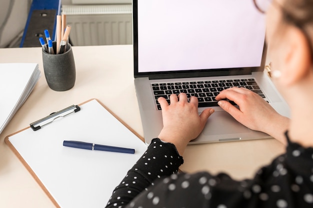 Donna dell'angolo alto che lavora ad un computer portatile vuoto dell'esposizione