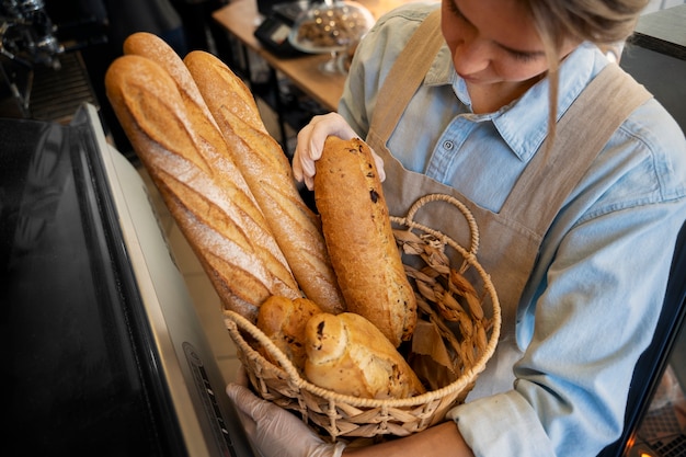 Donna dell'angolo alto che lavora in panetteria