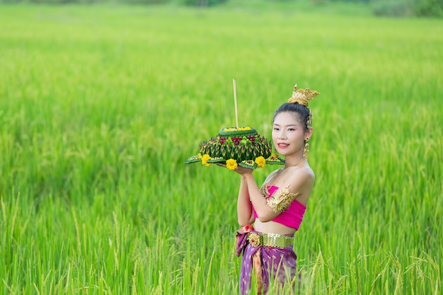 Donna dell'Asia nel kratong tradizionale della stretta del vestito tailandese. Festival di loy krathong