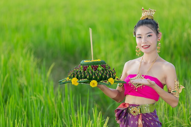 Donna dell'Asia nel kratong tradizionale della stretta del vestito tailandese. Festival di loy krathong