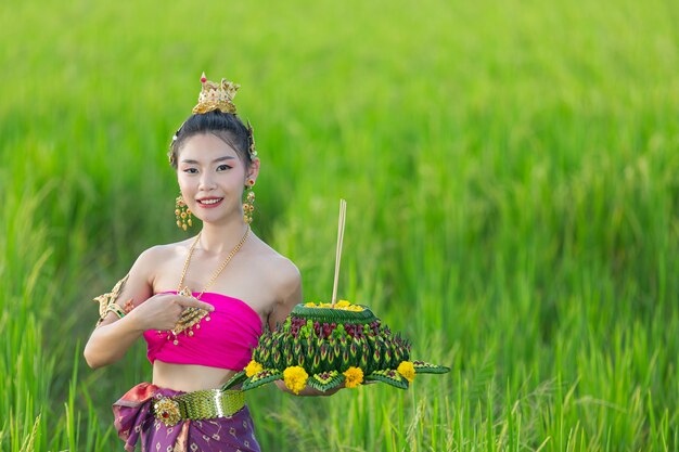 Donna dell'Asia nel kratong tradizionale della stretta del vestito tailandese. Festival di loy krathong