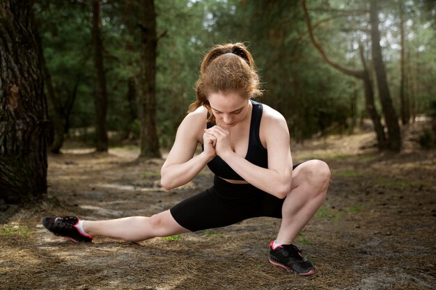 Donna della foto a figura intera che fa sport all'aperto