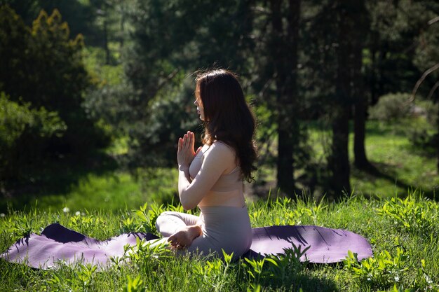 Donna della foto a figura intera che fa yoga sulla stuoia