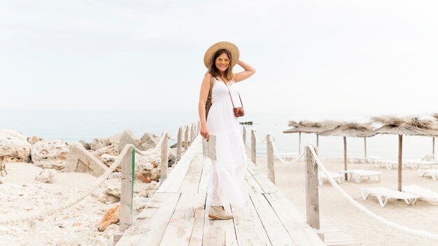 Donna della foto a figura intera che posa alla spiaggia