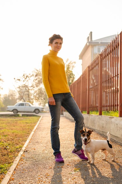 Donna della foto a figura intera con il suo cane all'aperto