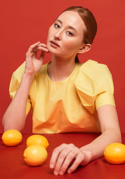 Donna della testarossa che posa con i limoni