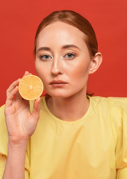 Donna della testarossa che posa con i limoni