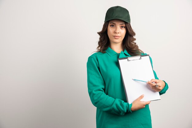 Donna delle consegne in uniforme verde che mostra i dettagli dell'ordine.