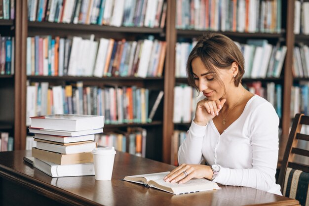 Donna dello studente che studia alla biblioteca