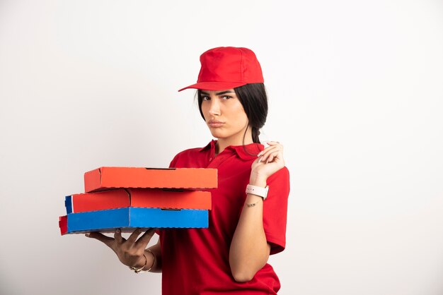 Donna depressa di consegna della pizza che tiene le scatole della pizza.