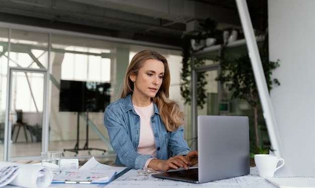 Donna di affari bionda che lavora al suo computer portatile