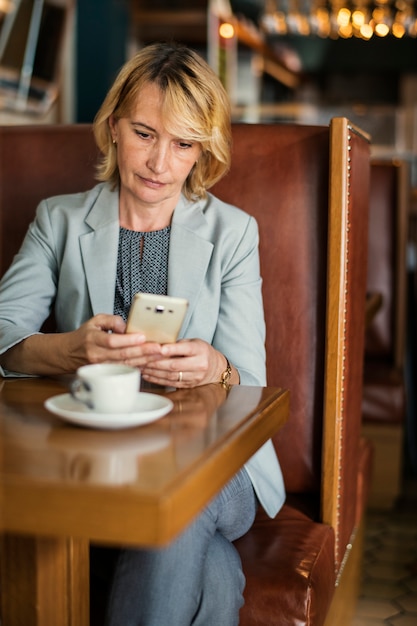 Donna di affari che lavora a distanza da un caffè