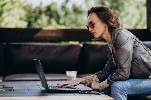 Donna di affari che lavora al computer portatile fuori casa