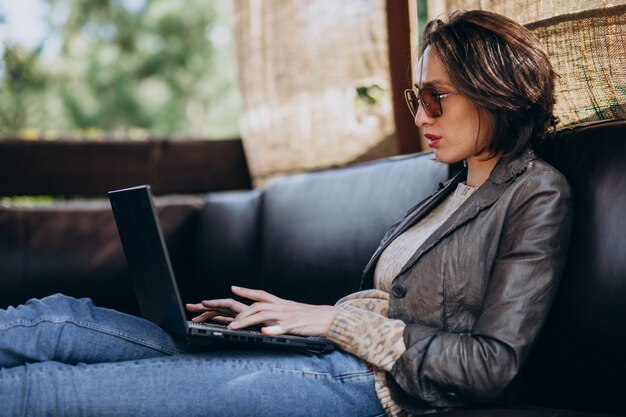 Donna di affari che lavora al computer portatile fuori casa