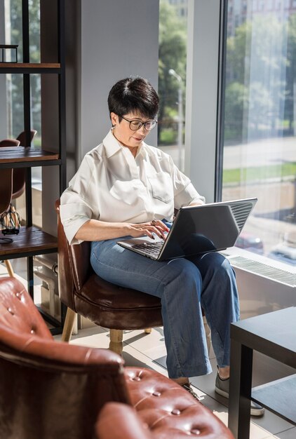 Donna di affari che lavora al suo computer portatile all'interno