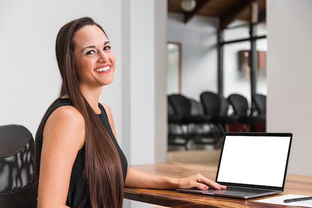 Donna di affari che lavora al suo modello del computer portatile