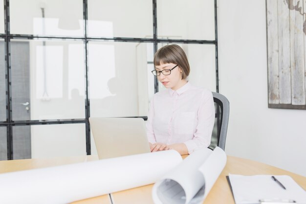 Donna di affari che lavora con il computer portatile in ufficio