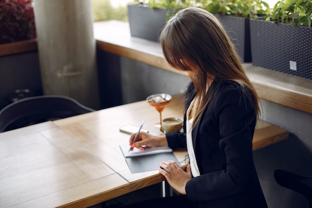 Donna di affari che si siede al tavolo in un caffè e di lavoro