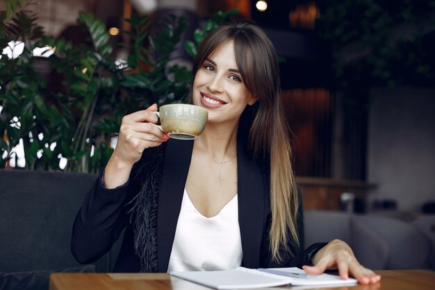 Donna di affari che si siede al tavolo in un caffè e di lavoro