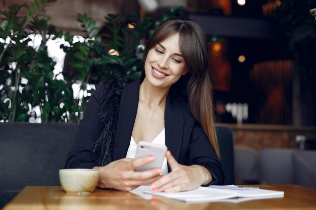 Donna di affari che si siede al tavolo in un caffè e di lavoro