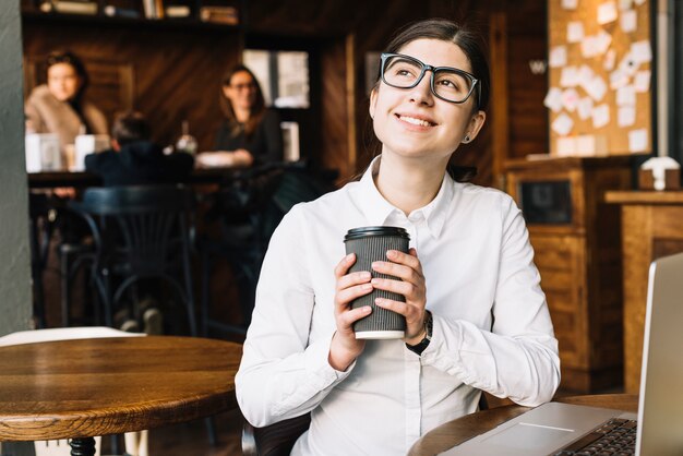 Donna di affari che sogna nella caffetteria