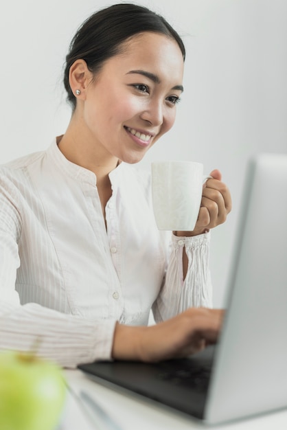 Donna di affari che sorride al computer portatile