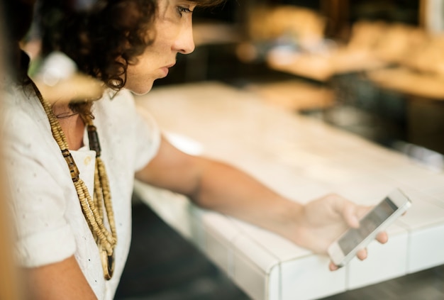 Donna di affari che utilizza telefono cellulare nella caffetteria