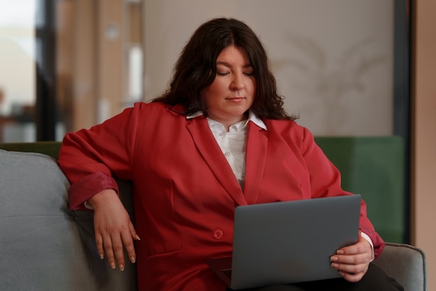 Donna di affari del colpo medio con il computer portatile
