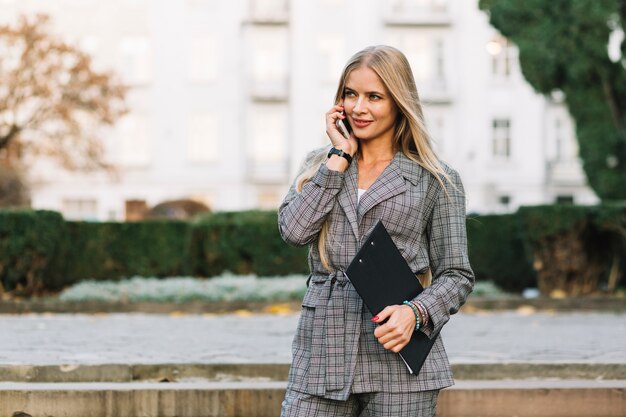 Donna di affari elegante che fa telefonata in città