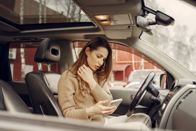 Donna di affari elegante che si siede in un'automobile