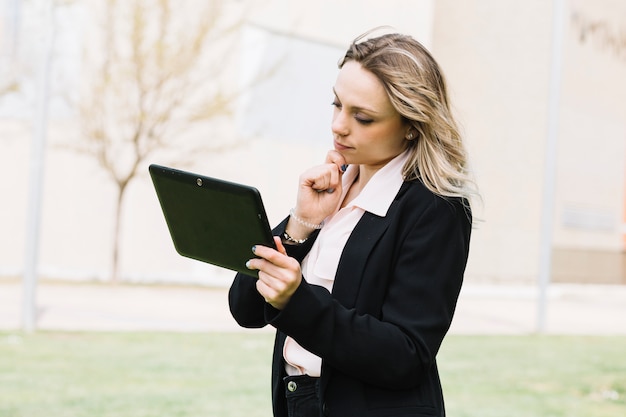 Donna di affari moderna con il computer portatile all&#39;aperto