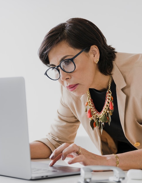 Donna di affari più anziana che lavora al computer portatile