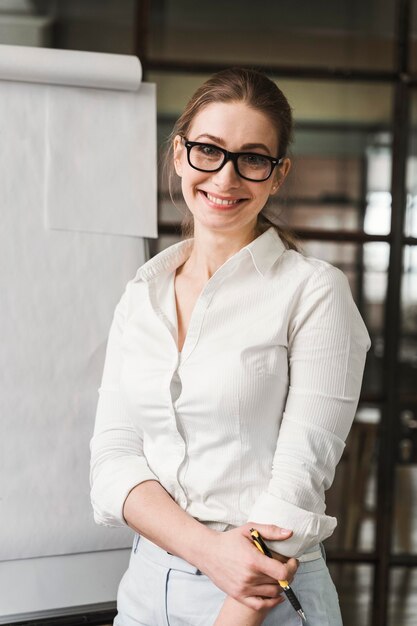 Donna di affari professionale di smiley con gli occhiali che fanno una presentazione