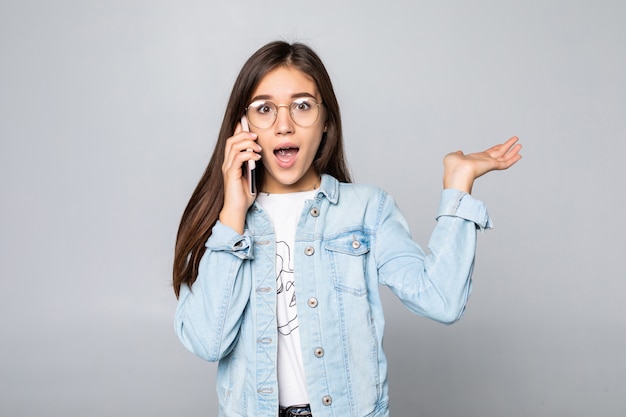 Donna di affari sorridente che parla sul telefono, isolato sulla parete bianca