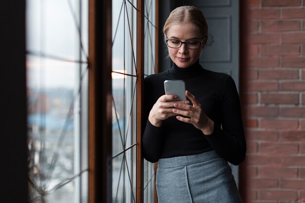 Donna di angolo basso che usando cellulare