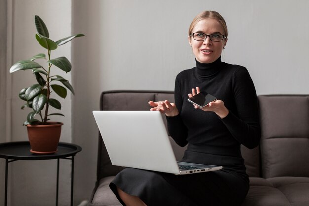 Donna di angolo basso con laptop e cellulare