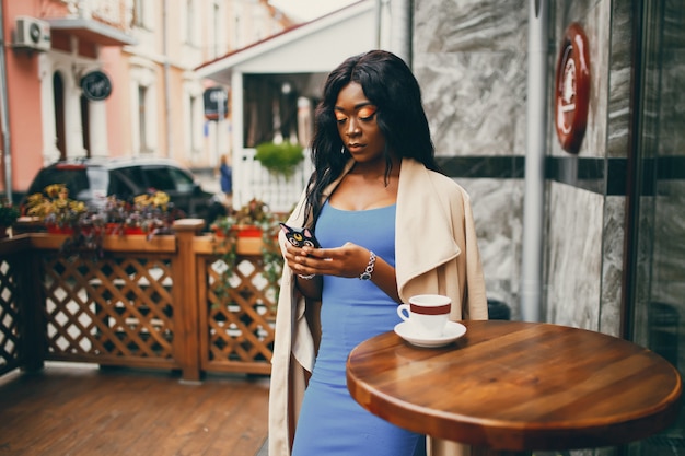 Donna di colore che beve un caffè in un caffè