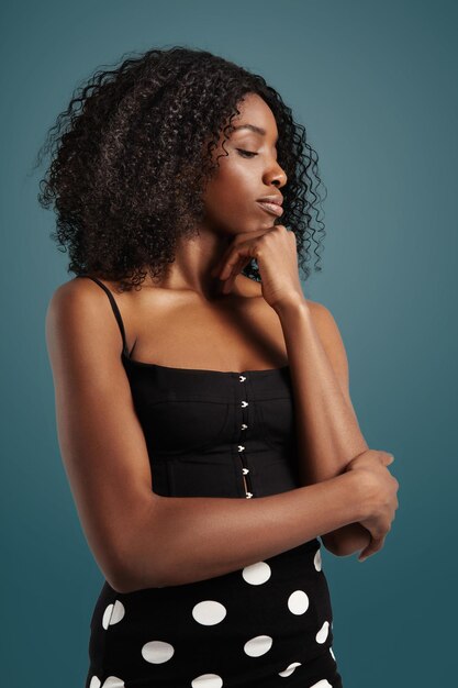 Donna di colore che guarda da parte con grandi capelli afro