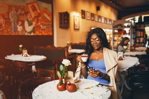 Donna di colore che si siede in un caffè