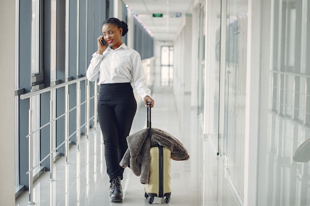 Donna di colore con la valigia in aeroporto