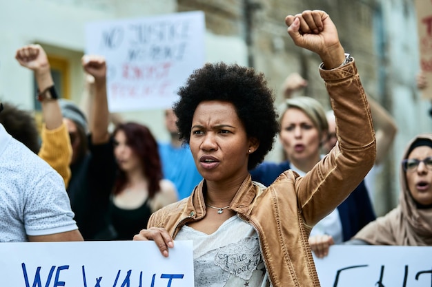 Donna di colore contrariata e folla di persone che manifestano contro il razzismo nelle strade della città
