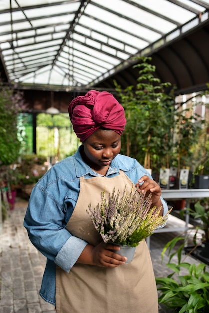 Donna di colore del colpo medio che gestisce un'azienda di fiori