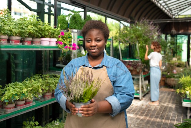 Donna di colore di vista frontale che gestisce un affare di fiori