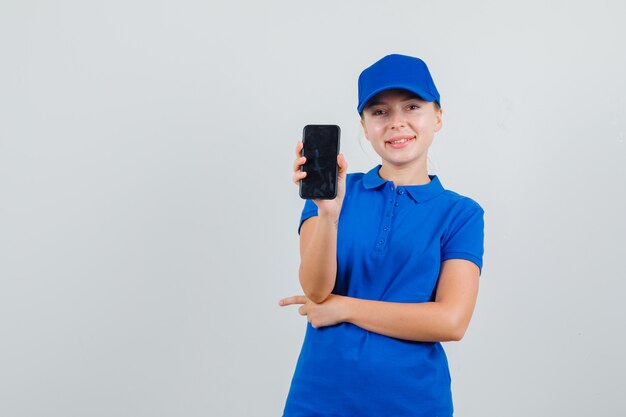 Donna di consegna che tiene il telefono cellulare in maglietta blu e berretto e sembra allegro