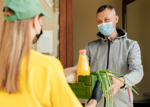 Donna di consegna del primo piano che tiene la cassa del cibo