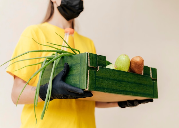 Donna di consegna del primo piano che tiene la cassa del cibo