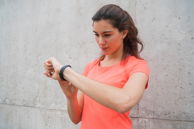 Donna di forma fisica che controlla tempo sull'orologio astuto.