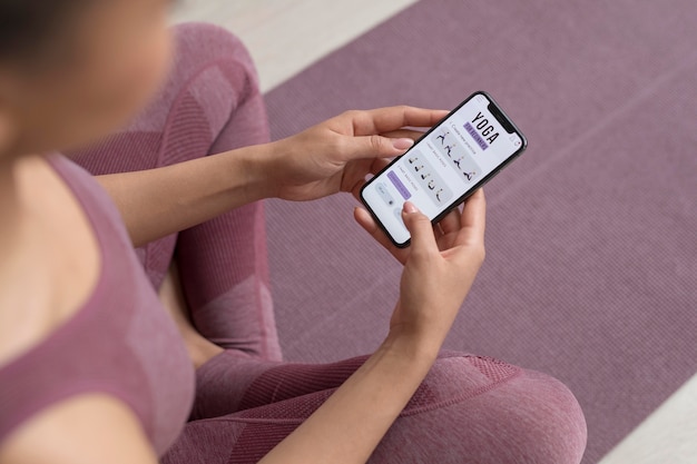 Donna di forma fisica che fa yoga con un'app mobile