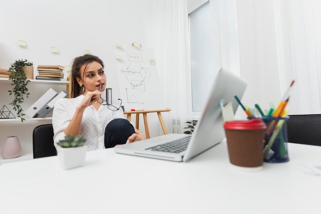 Donna di pensiero che si siede nel suo ufficio