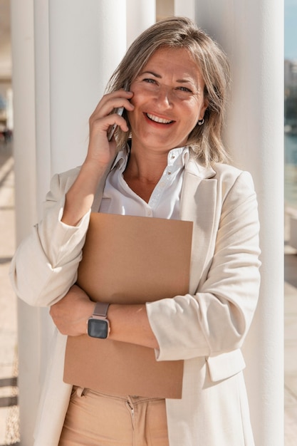 Donna di smiley che parla sul colpo medio del telefono